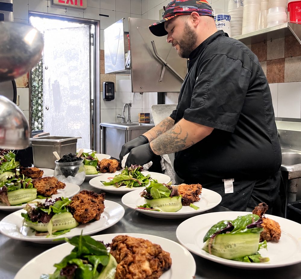 Executive Chef Michael Gargiulo plating a line of salads in the kitchen before service.