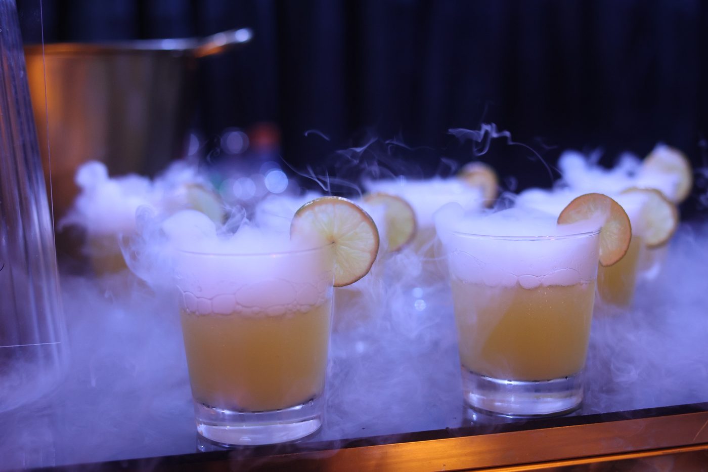 Dry-ice beverages served on arrival, smoke spilling over the rim of each glass.
