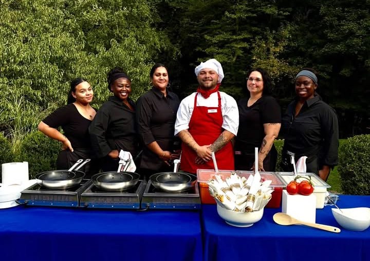 The Gargiulo Caterers crew behind a live sauté station, pans heating and plates ready to serve.